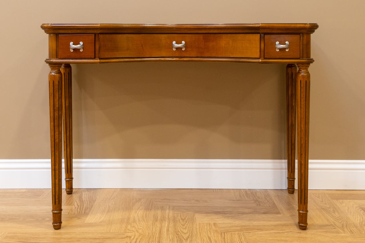 Elegant wooden console table featuring minimal design and three drawers with silver handles.
